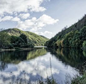 See mit Bergen, Wald und Grünflächen drum herum.